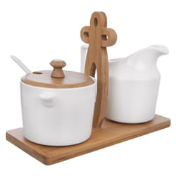 Elegant porcelain sugar bowl and cream jug on bamboo tray