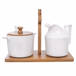 Elegant porcelain sugar bowl and cream jug on bamboo tray